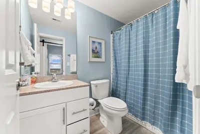 a bathroom with a toilet and a blue tiled shower at Spacious 3BD 2BA Beach Retreat! 5 Pool Resort! by Dolce Vita Getaways PCB in Panama City Beach