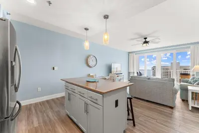 a kitchen and living room with a refrigerator at Spacious 3BD 2BA Beach Retreat! 5 Pool Resort! by Dolce Vita Getaways PCB in Panama City Beach
