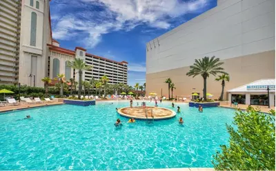 a pool at a resort with people in the water at Spacious 3BD 2BA Beach Retreat! 5 Pool Resort! by Dolce Vita Getaways PCB in Panama City Beach