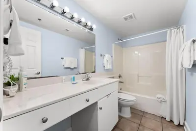 a white bathroom with a sink and a toilet at Shores of Panama Modern 2BR 2BA! Gulf View Resort! by Dolce Vita Getaways PCB in Panama City Beach