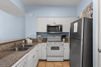 a kitchen with a stainless steel refrigerator and a sink at Shores of Panama Modern 2BR 2BA! Gulf View Resort! by Dolce Vita Getaways PCB in Panama City Beach