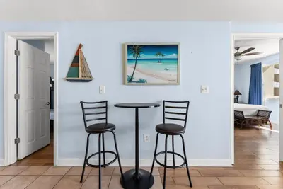 a living room with a table and two stools at Shores of Panama Modern 2BR 2BA! Gulf View Resort! by Dolce Vita Getaways PCB in Panama City Beach