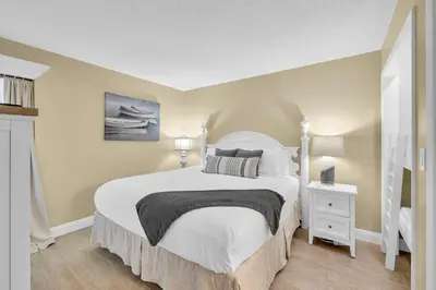 a bedroom with a large white bed and a white nightstand at Edgewater Resort! 2BR Sleeps 8! 1st Floor Condo! by Dolce Vita Getaways PCB in Panama City Beach