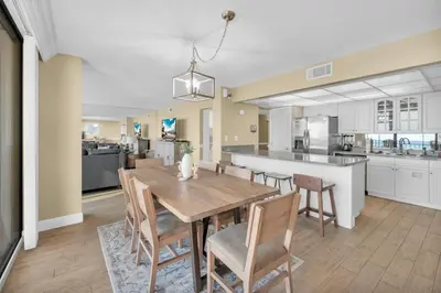 a kitchen and dining room with a wooden table and chairs at Edgewater Resort! 2BR Sleeps 8! 1st Floor Condo! by Dolce Vita Getaways PCB in Panama City Beach