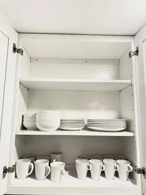 a cabinet filled with white dishes and plates at Mermaid's Den in Panama City Beach