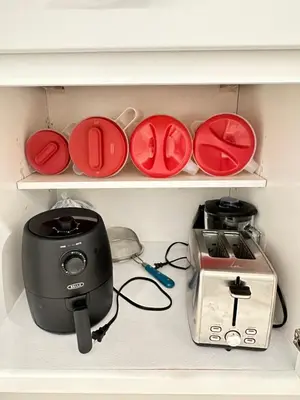 a shelf with a toaster and plates and a blender at Mermaid's Den in Panama City Beach