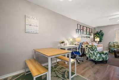 a living room with a table and a couch at Coastal Getaway! Walk to Beach! Pools & Tennis! Pet Friendly! by Dolce Vita Getaways PCB in Panama City Beach