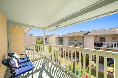 a balcony with a blue chair on a porch at Coastal Getaway! Walk to Beach! Pools & Tennis! Pet Friendly! by Dolce Vita Getaways PCB in Panama City Beach