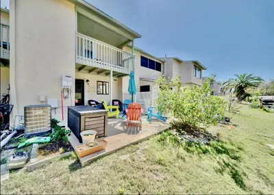 a house with a patio with chairs and a grill at Coastal Getaway! Walk to Beach! Pools & Tennis! Pet Friendly! by Dolce Vita Getaways PCB in Panama City Beach