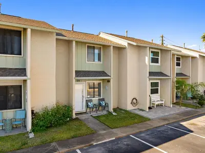 a building with chairs in a parking lot at Coastal Getaway! Walk to Beach! Pools & Tennis! Pet Friendly! by Dolce Vita Getaways PCB in Panama City Beach