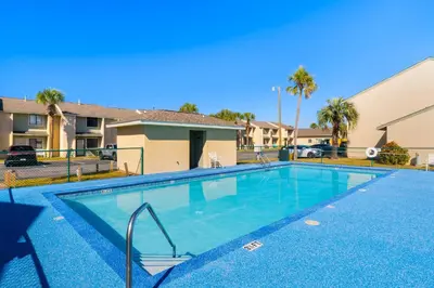 a swimming pool in a villa with palm trees at Coastal Getaway! Walk to Beach! Pools & Tennis! Pet Friendly! by Dolce Vita Getaways PCB in Panama City Beach