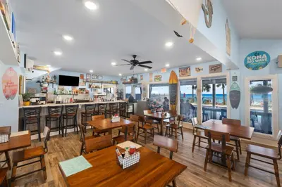 a restaurant with tables and chairs and a bar at Coastal Getaway! Walk to Beach! Pools & Tennis! Pet Friendly! by Dolce Vita Getaways PCB in Panama City Beach