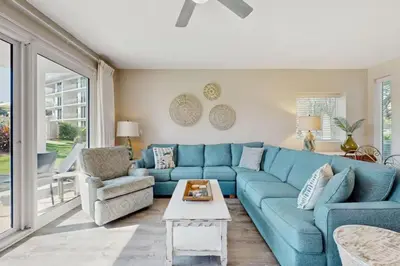 a blue couch and a chair in a living room at High Pointe Resort 115 in Seacrest