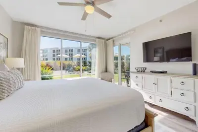 a white bedroom with a large bed and a large window at High Pointe Resort 115 in Seacrest