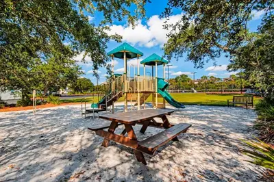 a playground with a slide and a picnic table at High Pointe Resort 115 in Seacrest