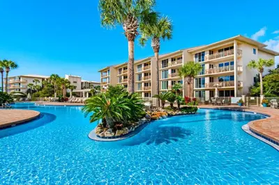 a swimming pool with palm trees in front of a building at High Pointe Resort 115 in Seacrest