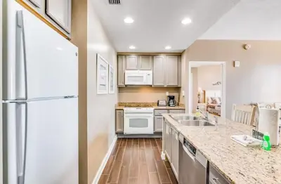 a kitchen with a sink and a refrigerator at Sterling Reef 405 by Emerald Coast Retreats in Panama City Beach