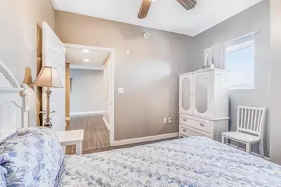 a bedroom with a bed and a dresser and a chair at Sterling Reef 405 by Emerald Coast Retreats in Panama City Beach
