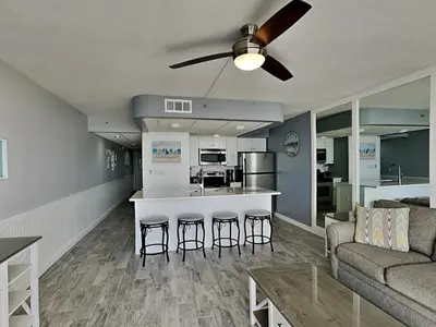 a living room with a couch and a kitchen at Your Paradise Awaits! in Panama City Beach