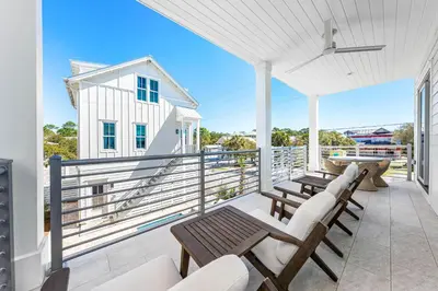 a patio with benches and tables on a balcony at 30A Sunrise and Sunset in Santa Rosa Beach