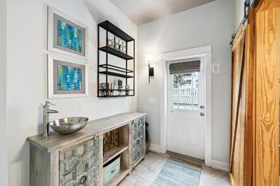 a bathroom with a sink and a door at Downward Dog by 30A Escapes in Seacrest