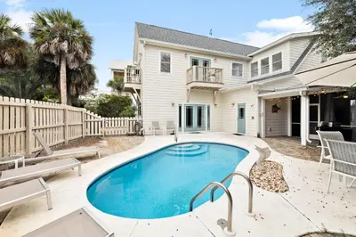 a swimming pool in front of a house at Downward Dog by 30A Escapes in Seacrest