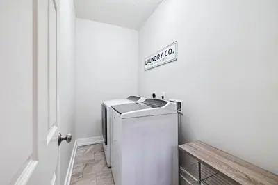 a laundry room with a white refrigerator and a sign at Downward Dog by 30A Escapes in Seacrest