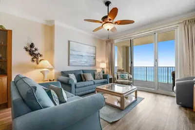 a living room with a blue couch and a table at Ocean Reef Starfish in Panama City Beach