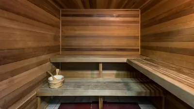 a sauna with wooden walls and benches and a bucket at Ocean Reef Starfish in Panama City Beach