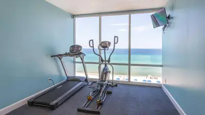 a gym with two exercise bikes in front of a window at Ocean Reef Starfish in Panama City Beach