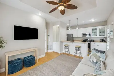a living room with a couch and a flat screen tv at Tram-on-Time Carriage House by 30A Escapes in Rosemary Beach