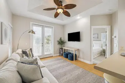 a living room with a couch and a ceiling fan at Tram-on-Time Carriage House by 30A Escapes in Rosemary Beach