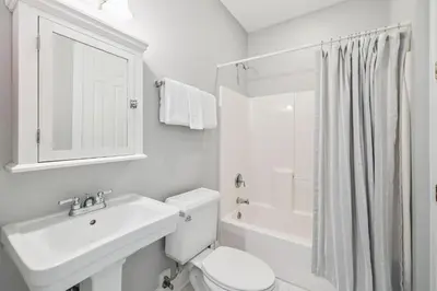 a white bathroom with a sink and a toilet at Tram-on-Time Main House by 30A Escapes in Rosemary Beach