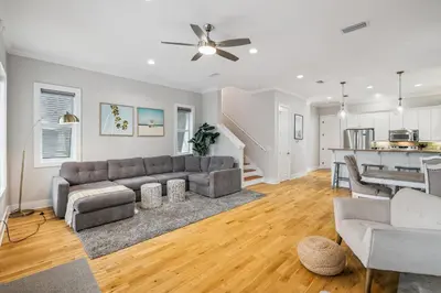a living room with a couch and a kitchen at Tram-on-Time Main House by 30A Escapes in Rosemary Beach