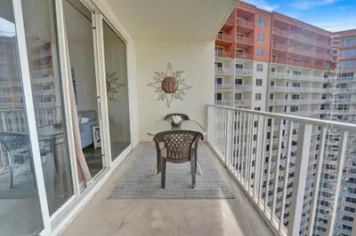 a chair on a balcony with a view of a building at Blue Skies at Shores in Panama City Beach