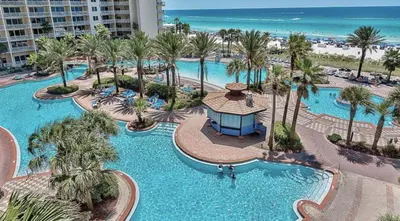 an aerial view of a resort with palm trees and the beach at Blue Skies at Shores in Panama City Beach
