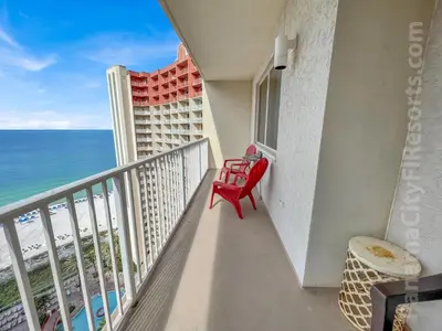 a balcony with a red chair and the ocean at Blue Skies at Shores in Panama City Beach