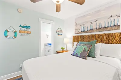 a bedroom with a white bed and a ceiling fan at Perching Pretty at Sunbird in Panama City Beach