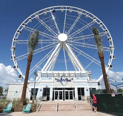 a large ferris wheel in front of a building at Perching Pretty at Sunbird in Panama City Beach