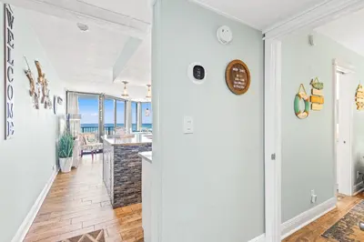 a kitchen and living room with a view of the ocean at Perching Pretty at Sunbird in Panama City Beach
