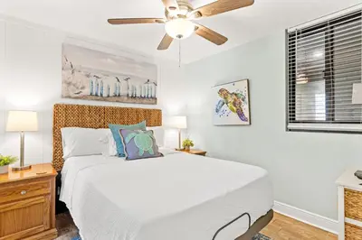 a white bedroom with a bed and a ceiling fan at Perching Pretty at Sunbird in Panama City Beach