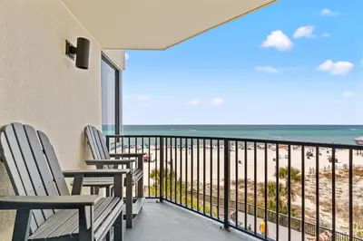 a balcony with chairs and a view of the beach at Perching Pretty at Sunbird in Panama City Beach