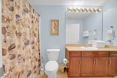 a bathroom with a toilet and a sink and a mirror at Sea Turtle at Laketown Wharf in Panama City Beach