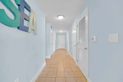 a hallway with white walls and a tile floor at Sea Turtle at Laketown Wharf in Panama City Beach