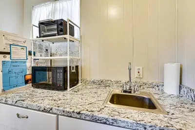 a kitchen counter with a sink and a microwave at Steps to Sand! PCB Haven with Furnished Outdoor Area in Panama City Beach