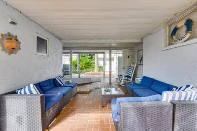 a living room with blue couches and a table at Steps to Sand! PCB Haven with Furnished Outdoor Area in Panama City Beach