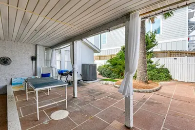 a patio with a bed and a table on a patio at Steps to Sand! PCB Haven with Furnished Outdoor Area in Panama City Beach