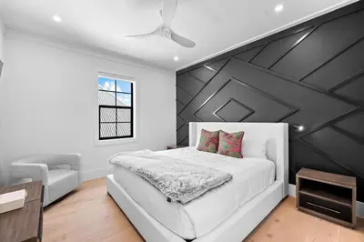 a bedroom with a white bed and a black accent wall at Endless Views 30A in Santa Rosa Beach