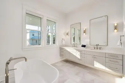 a white bathroom with two sinks and a mirror at Pelayo Solage in Santa Rosa Beach