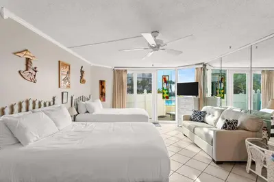 a living room with a bed and a couch at Beach Front Ocean View Condo - Top of the Gulf 105 in Panama City Beach